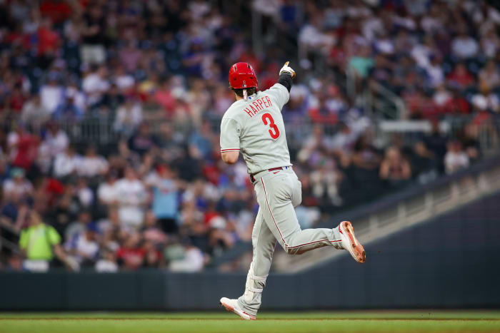 Bryce Harper runs and points to the fans in the stadium with his right hand